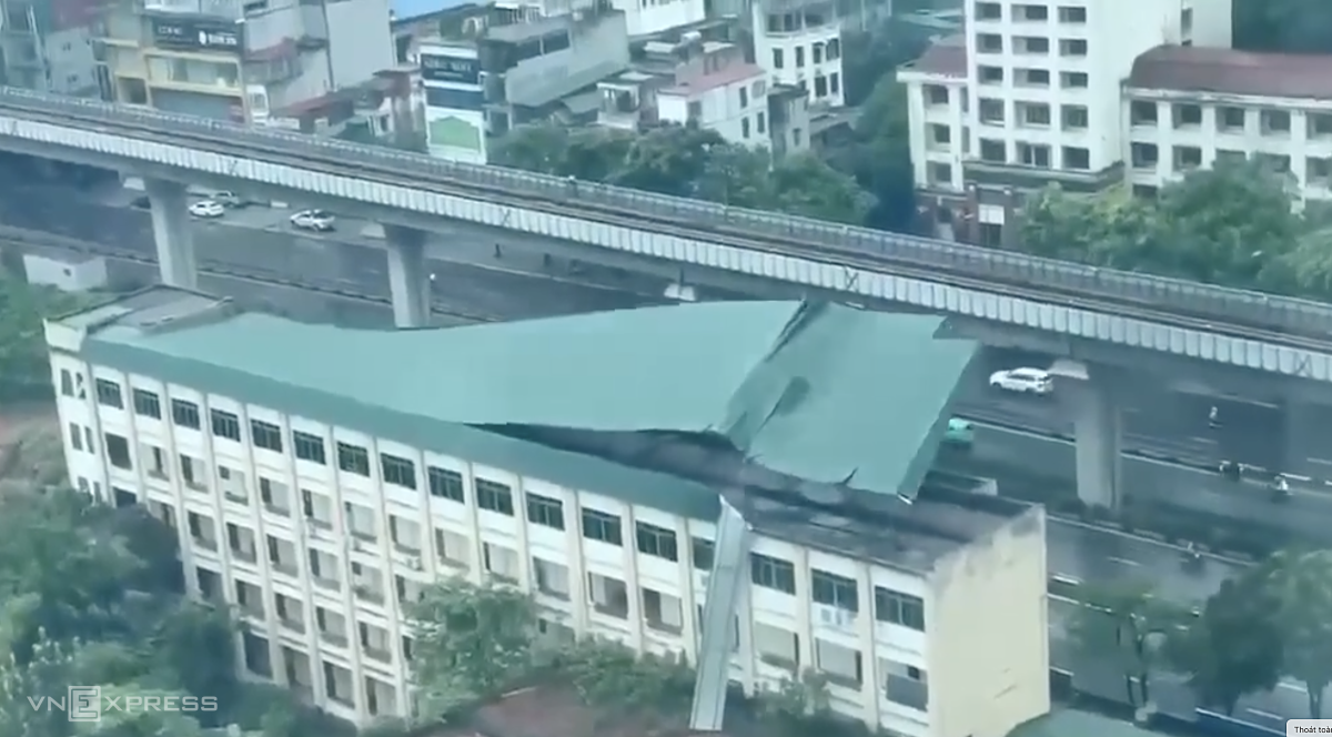 Nằm cách xa tâm bão nhưng Hà Nội gió lốc từng cơn từ buổi sáng. Đến đầu giờ chiều tốc độ gió tăng lên, giật dữ dội, thổi bay mái tôn nhà xưởng Công ty giày ở Thượng Đình, Thanh Xuân, Hà Nội. Ảnh cắt từ clip.