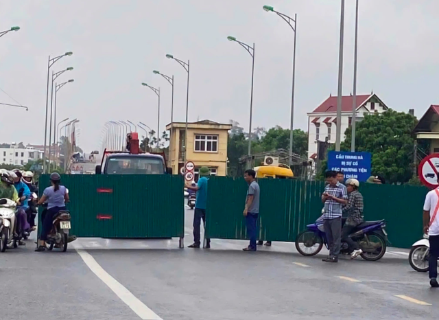 Lực lượng chức năng lập hàng rào ngăn người dân đi lên cầu Trung Hà. Ảnh: G.T.