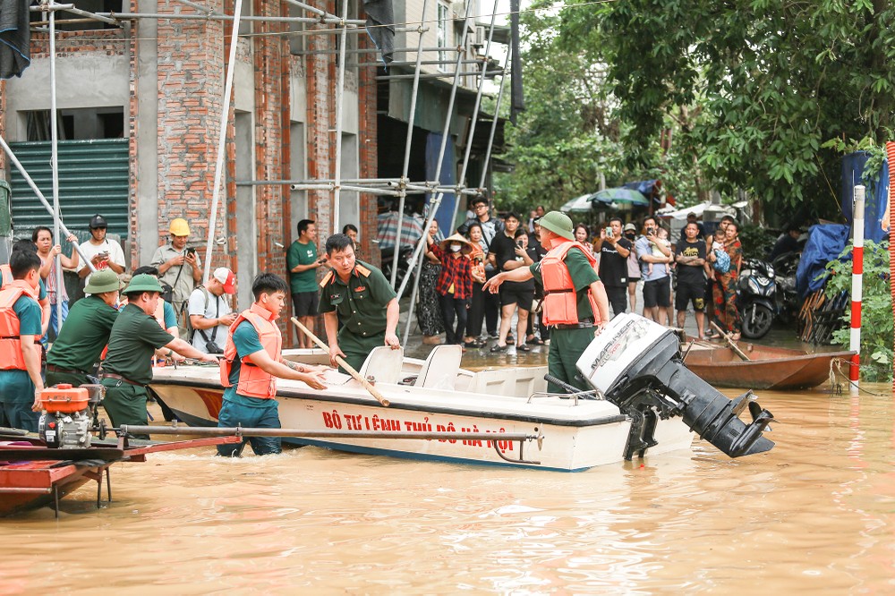 Những ngày qua, nước sông Hồng lên chủ yếu vẫn do lũ từ các dòng sông nhỏ trên thượng nguồn đổ về và các hồ thủy điện lớn thì tích nước chống lũ. Nhưng khi lũ từ các sông nhỏ giảm xuống và nước trong các hồ thủy điện đẩy lên, thì bắt đầu phải tính toán việc xả lũ. Chẳng hạn, Tuyên Quang là hồ thủy điện lớn nhất vùng Đông Bắc bộ, vào lúc 15 giờ 30 chiều nay đã xả với mức 4369m3/s, để đưa về mực nước thấp hơn, chuẩn bị dung tích đón lũ tiếp theo nếu xảy ra. Còn Hòa Bình, nấc thang thủy điện cuối cùng của sông Đà – nguồn lũ chính từ Tây Bắc bộ, vẫn còn nỗ lực cắt lũ, với tổng lưu lượng xả 3.899m3/s so với lượng nước về hồ 4.996m3/s. Các diễn biến thời tiết cho thấy người dân vùng ngoài đê sông Hồng ở Hà Nội vẫn phải chuẩn bị cho khả năng nước lên cao hơn.