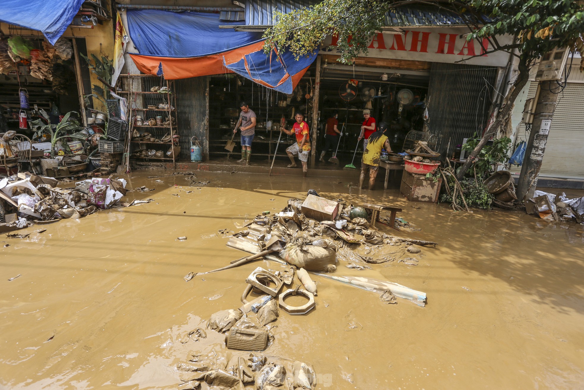 Sau khi nước rút, người dân ở đây đào bới lớp bùn đặc quánh, sâu ngang đầu gối mong tìm kiếm những tài sản còn sót lại. Họ cố gắng dọn dẹp khi bùn chưa khô để sớm ổn định cuộc sống.