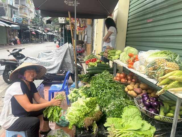 Bó rau xanh trên tay tiểu thương này có giá bán là 25.000 đồng, trong khi ở thời điểm trước bão, bó rau này chỉ 8.000 đồng.