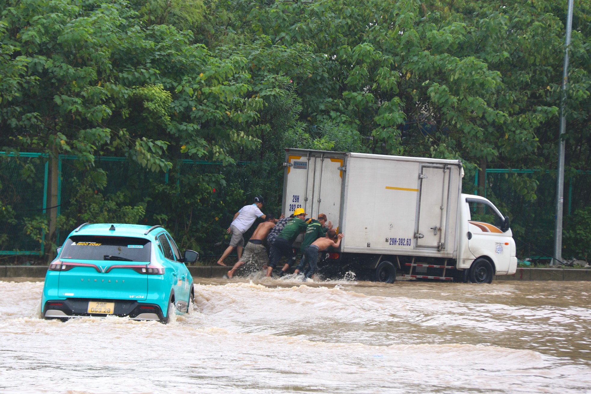 Tại những khu vực ngập, nhiều dịch vụ hỗ trợ các phương tiện bị chết máy nở rộ như đẩy xe chết máy, kéo xe và sửa xe qua đoạn ngập.