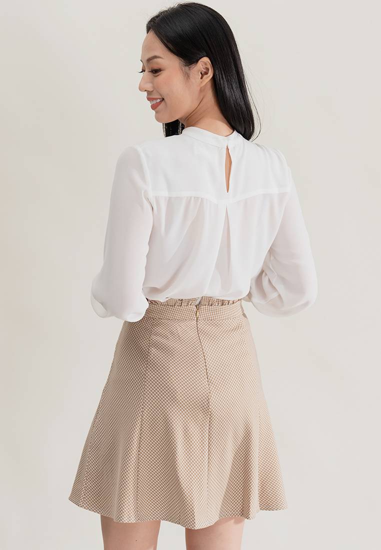 Chân váy màu be và áo blouse tạo nên tổng thể hài hòa.