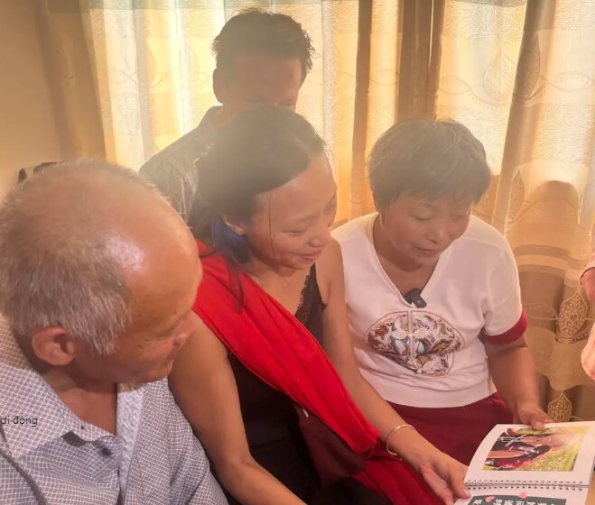 Cả gia đình cùng nhau xem album ảnh ghi lại quá trình trưởng thành của con gái.