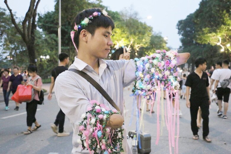 Hình ảnh chàng trai bán vòng hoa đội đầu trên bờ hồ đã nhận được sự quan tâm của rất nhiều người...