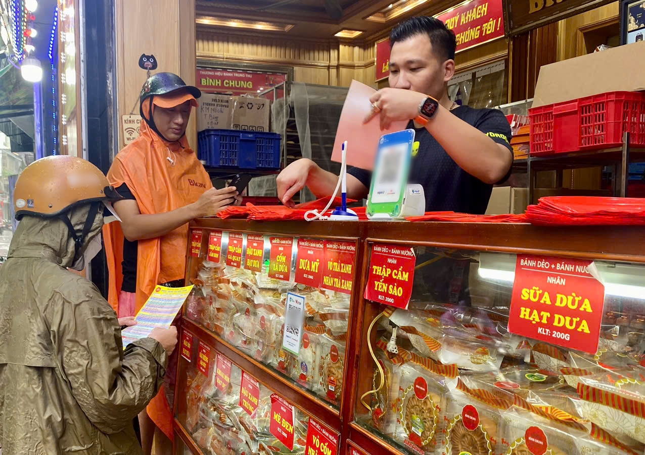 Một số người dân đội mưa đi mua bánh trung thu.