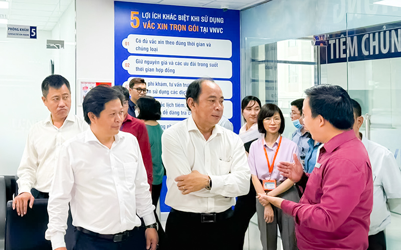 PGS.TS Tăng Chí Thượng (hàng đầu, thứ hai từ trái qua) và đoàn công tác đến thăm, giám sát việc triển khai chiến dịch tiêm vắc xin sởi miễn phí cho trẻ 1-10 tuổi sáng 17/9 tại VNVC quận 8 (TP.HCM). Ảnh: Mộc Thảo