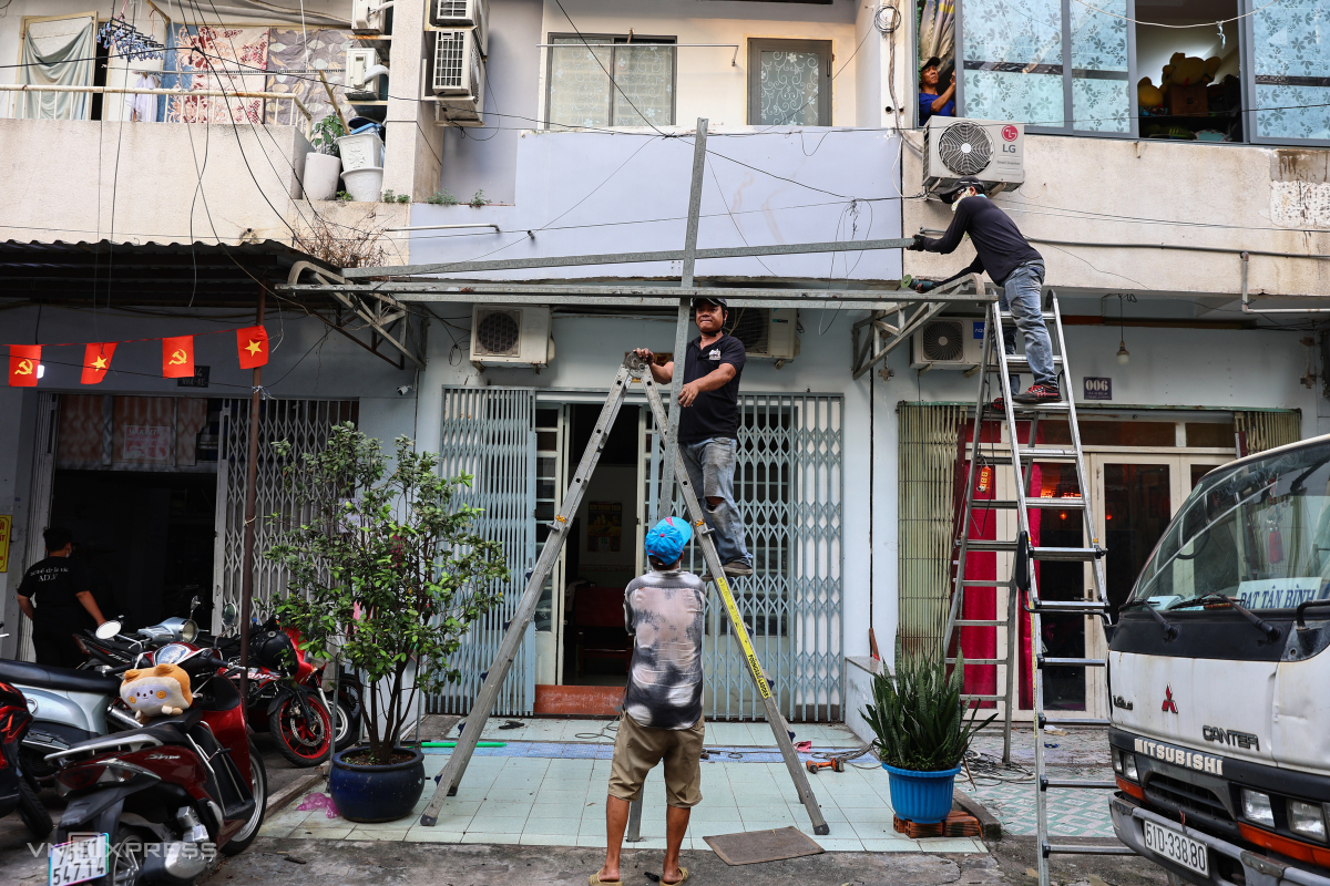 Ở dưới tầng trệt, hàng loạt hộ dân cũng tất bật tháo phần mái hiên, hàng rào cơi nới không đúng thiết kế ban đầu của cư xá.
