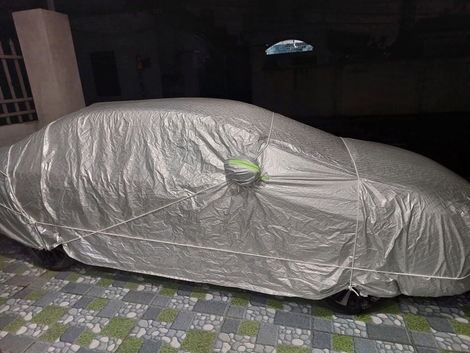 Vợ chồng chị Duyên ở TP Hải Phòng phủ bạt ôtô vào tối 20/7, trước khi dùng các tấm xốp dày quanh thân xe vào sáng hôm sau. Ảnh: Nguyễn Duyên