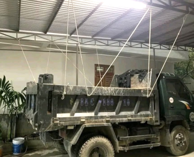 Anh Bình An dùng dây thừng cố định xe tải với mái tôn của gia đình tại phường Việt Hòa, TP Hải Phòng hôm 20/7, hy vọng không bị tốc bay khi bão đổ bộ. Ảnh: Bình An