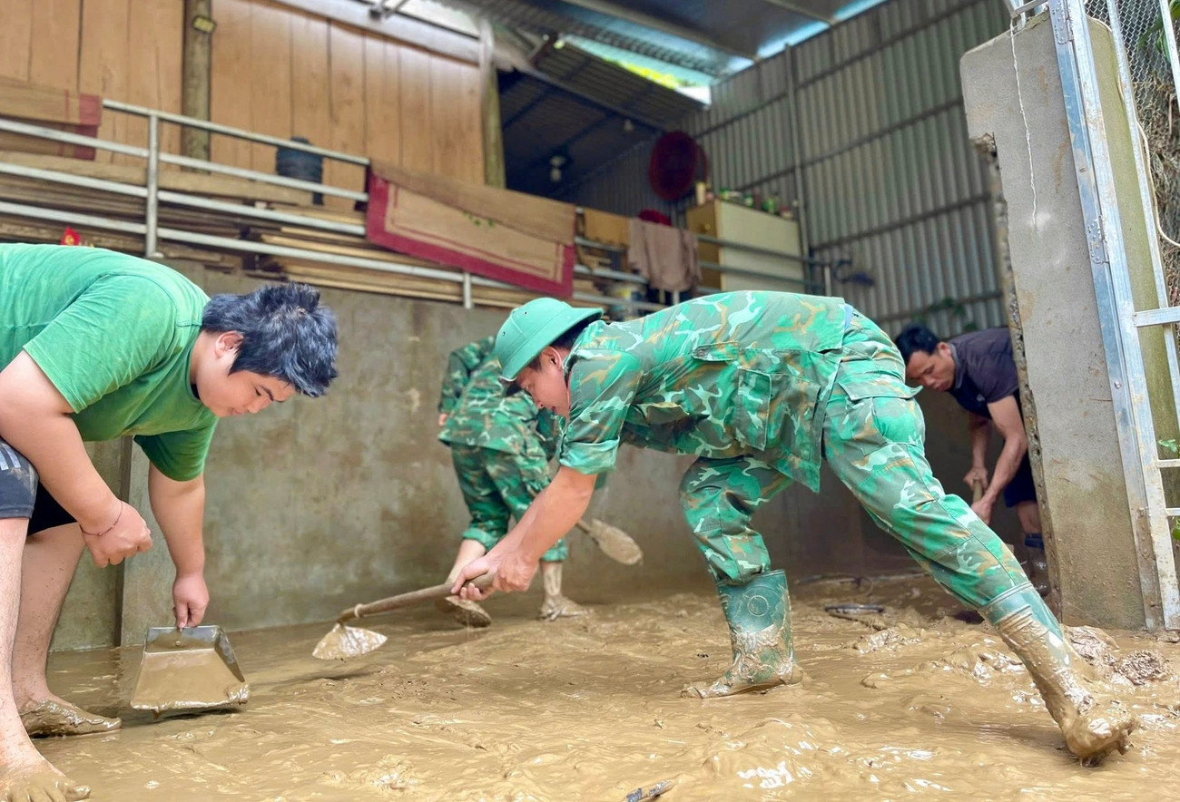 Cán bộ, chiến sĩ Đồn Biên phòng Nậm Càn giúp các hộ gia đình dọn dẹp, xúc bùn đất, sắp xếp lại vật dụng sinh hoạt cho các hộ dân bị ảnh hưởng nặng bởi mưa lũ tại bản Khe Kiền.