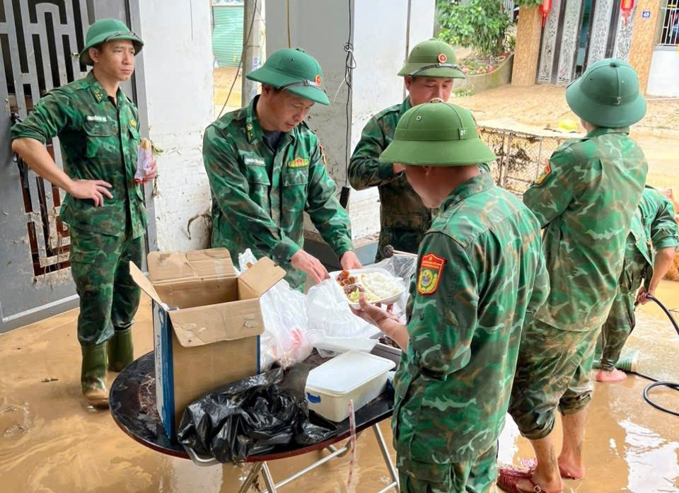 Bữa cơm ăn vội của lực lượng vũ trang trên đường giúp người dân dọn lũ.