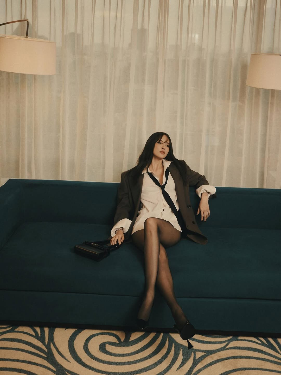 Trong bộ ảnh, Thiều Bảo Trâm diện một chiếc áo sơ mi trắng dáng rộng kết hợp cùng blazer màu nâu đất phóng khoáng và cà vạt buông lơi, tạo nên vẻ ngoài vừa lịch lãm, vừa phá cách.