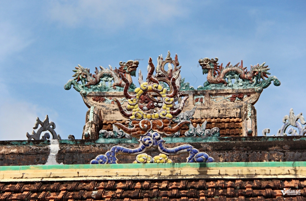 Đầu đao (ảnh trái) với nhiều họa tiết mềm mại, hình rồng. Mái đình (ảnh phải) có hình tượng đôi rồng chầu quả cầu lửa.  Ảnh: Hà Nguyễn