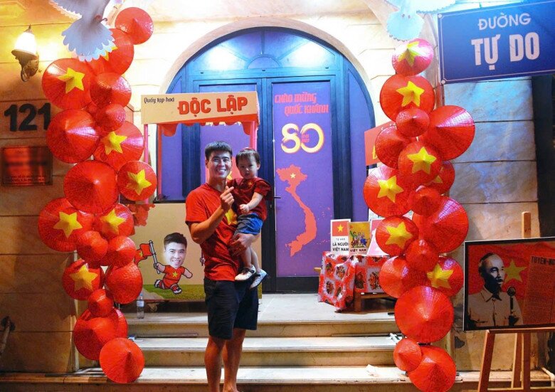 Duy Mạnh bế con gái trước cửa nhà. Toàn bộ mặt tiền ngôi nhà được tận dụng tối đa mà vẫn giữ được sự ngăn nắp. Phần sàn trước cửa không bị bày biện quá nhiều, giúp giữ lối đi thông thoáng và tạo khoảng trống dễ chịu cho người ghé qua.