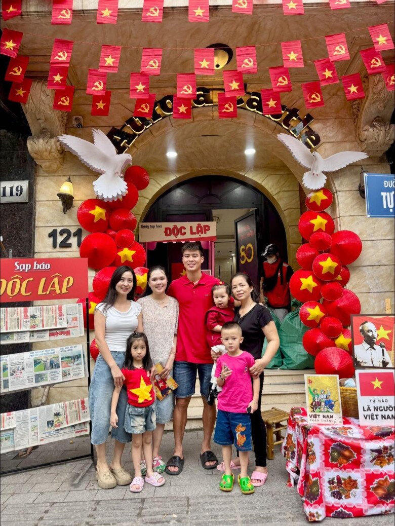 Hệ thống đèn hắt vàng ấm áp, phần mái vòm đá giúp mặt tiền giữ được vẻ sang trọng giữa những chi tiết rực rỡ. Hai cột nón đỏ hai bên tạo cảm giác như cổng chào lễ hội.