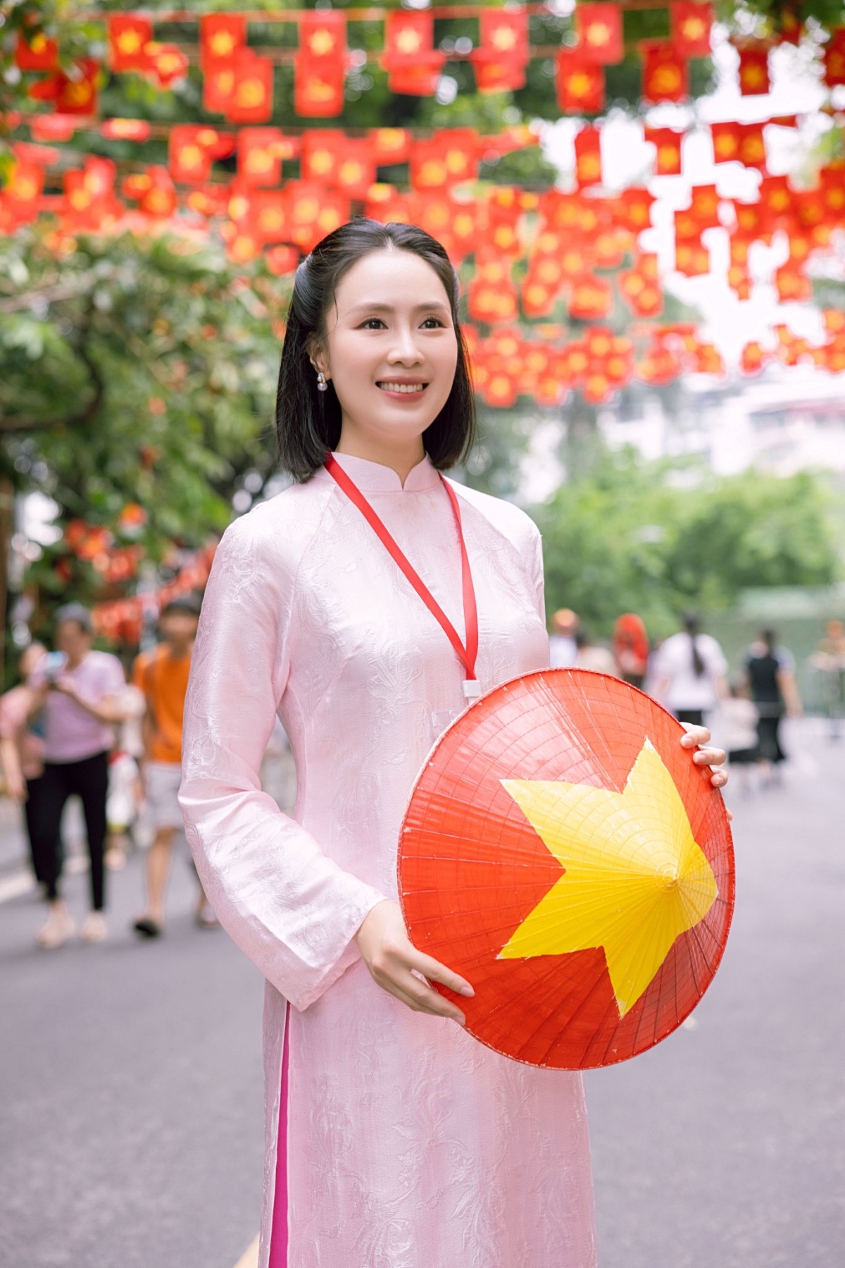 Diễn viên Hồng Diễm sử dụng nón lá sao vàng làm điểm nhấn trên nền xiêm y hồng pastel tại buổi sơ duyệt diễu binh, diễu hành.