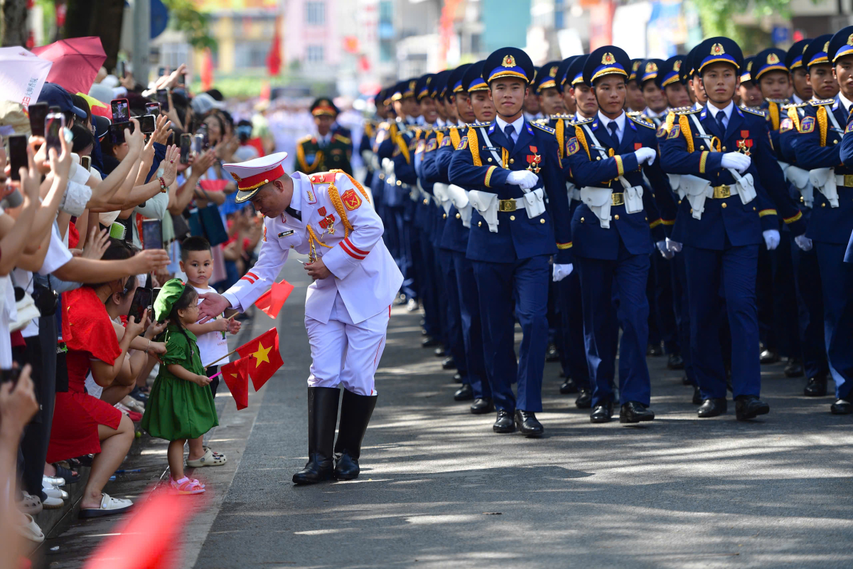 Nam sĩ quan Quân nhạc đùa vui cùng hai em bé trên phố Ngọc Hà. Ảnh: Thanh Tùng