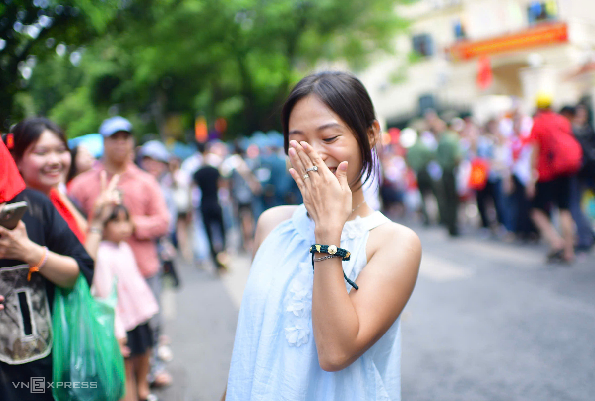 Cô gái mỉm cười giữa phố đông khoe chiếc vòng tay được làm từ quân trang mà chiến sĩ trong đoàn diễu binh tặng. Ảnh: Thanh Tùng