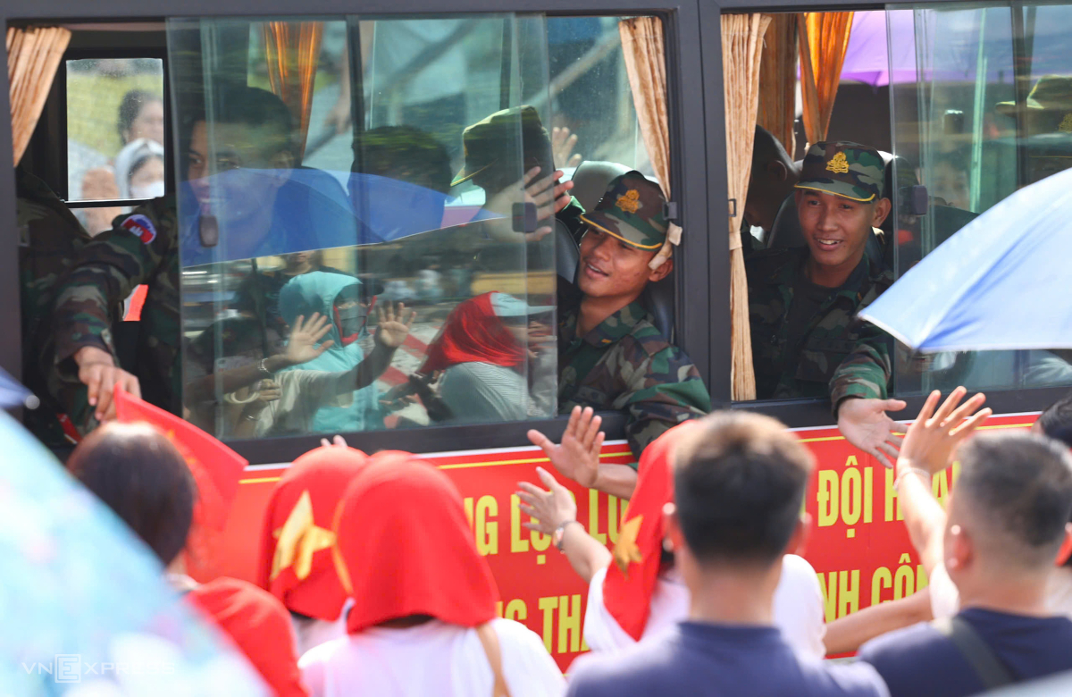 Các quân nhân Khối Quân đội Hoàng gia Campuchia vẫy chào người dân trên phố. Đoàn 120 người đến Việt Nam hôm 15/8 và luyện tập trong Trung tâm huấn luyện quốc gia Miếu Môn. Năm 2025, các đại diện của Quân đội Campuchia đã có hai lần dự diễu binh của Việt Nam, vào dịp 30/4 ở TP HCM và 2/9 tại Hà Nội. Ảnh: Trần Quỳnh