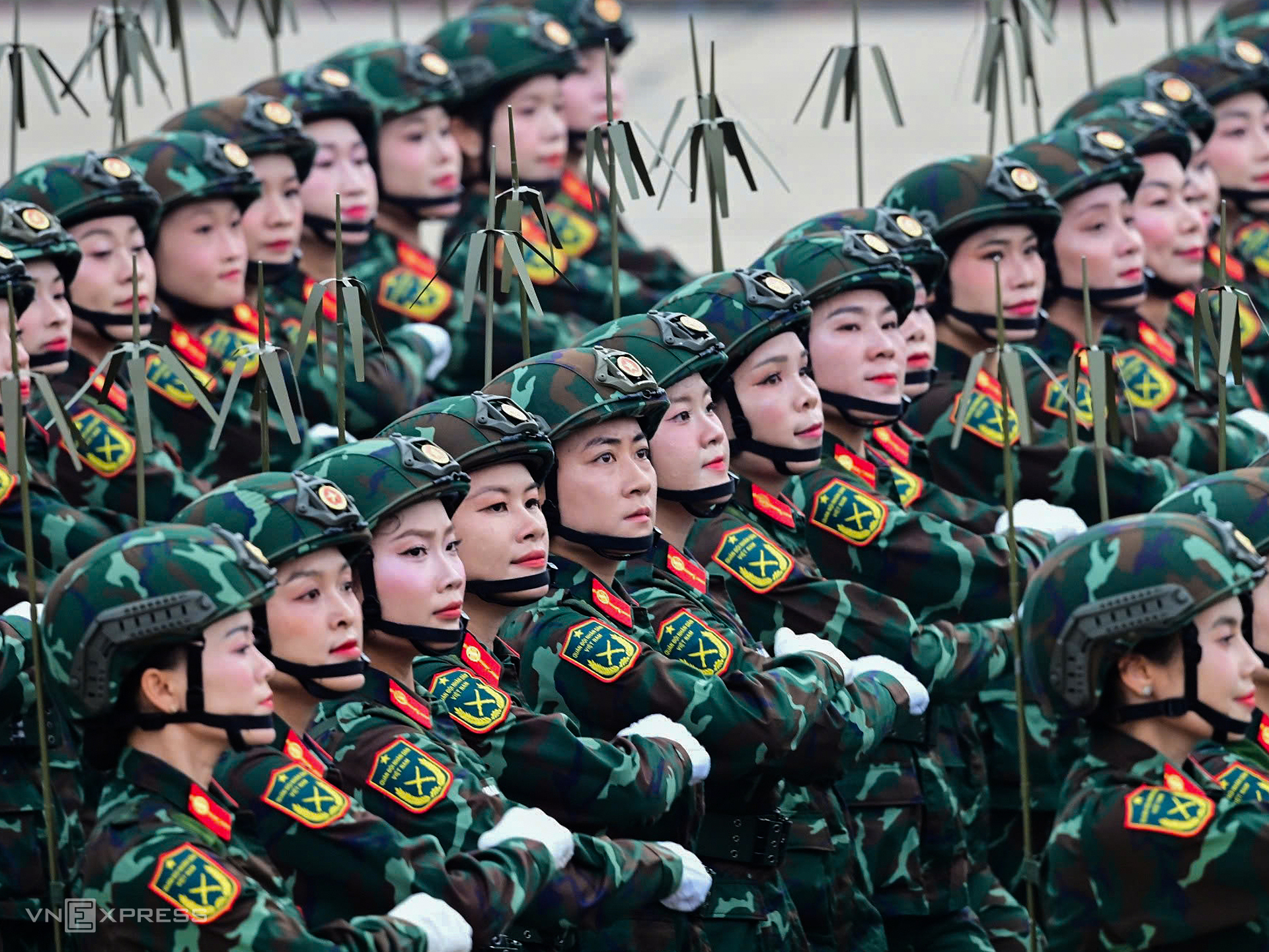 Khối nữ Thông tin liên lạc đội mũ chiến đấu, đeo máy vô tuyến điện, diễu hành qua lễ đài. Ảnh: Thanh Tùng