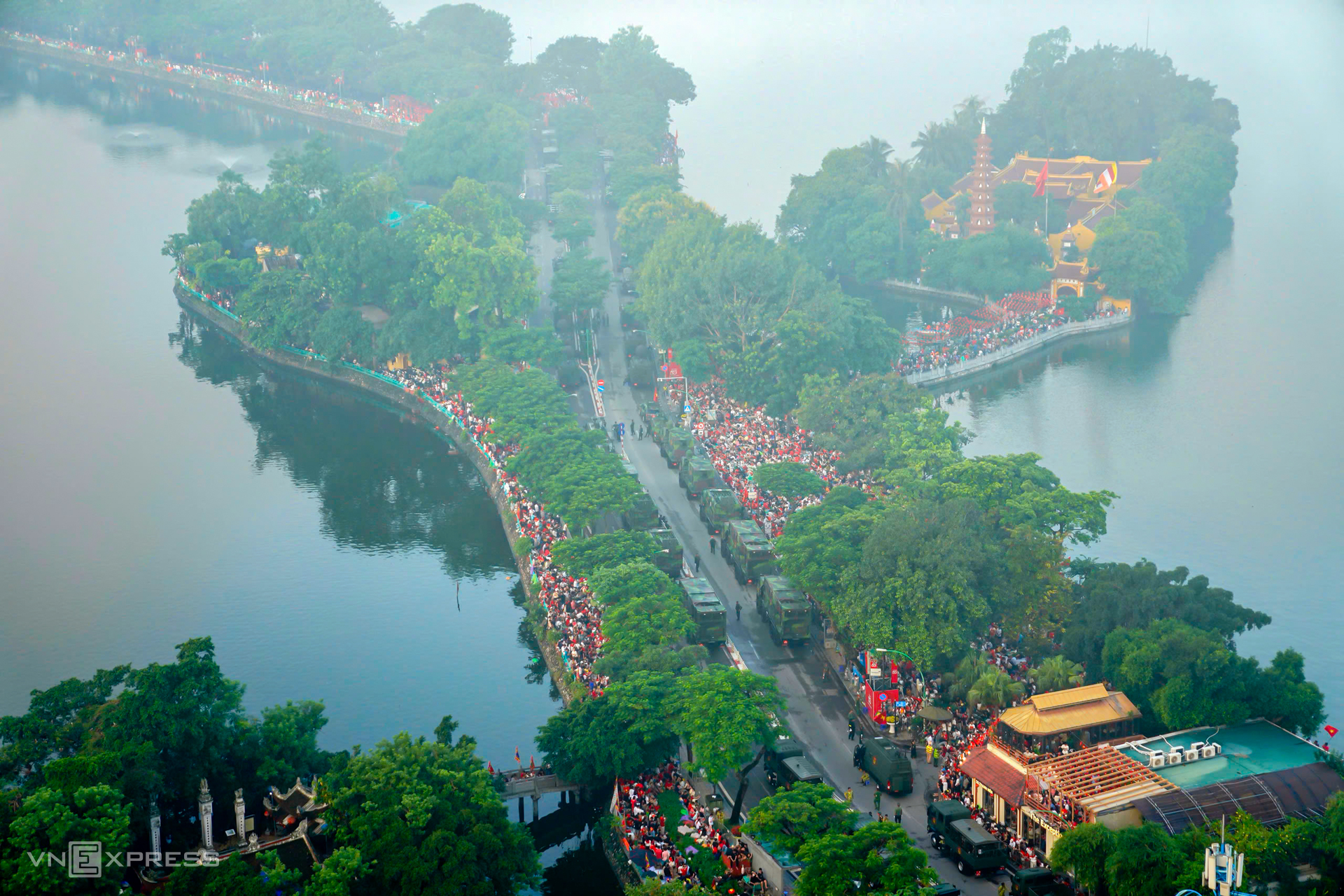 Dàn xe bánh xích, bánh lốp trên đường Thanh Niên, ven hồ Tây nằm chờ lệnh tiến vào lễ đài trên quảng trường Ba Đình, sáng 2/9. Khu vực này đông kín người dân hai bên đường, an ninh được thắt chặt. Ảnh: Nguyễn Đông