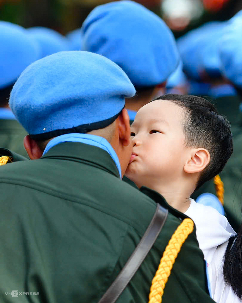 Bé Hoàng Quân theo bà đi xem diễu binh, ôm hôn một sĩ quan Cảnh sát Gìn giữ hòa bình Liên Hợp Quốc hôm tổng duyệt diễu binh, sáng 30/8. Ảnh: Thanh Tùng