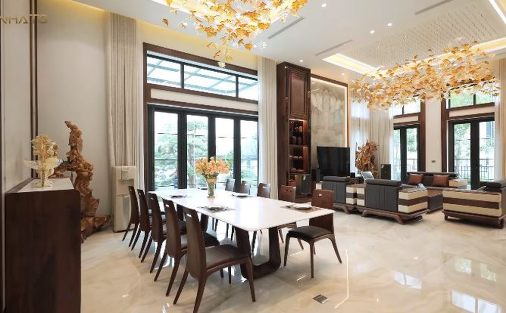 Tầng 1 là không gian phòng khách và bếp rộng thoáng, được bố trí nhiều đồ gỗ óc chó Mỹ. Ảnh chụp màn hình