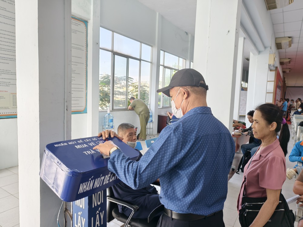 Hành khách đang lấy số thứ tự để mua vé tàu Tết. Ảnh: TN