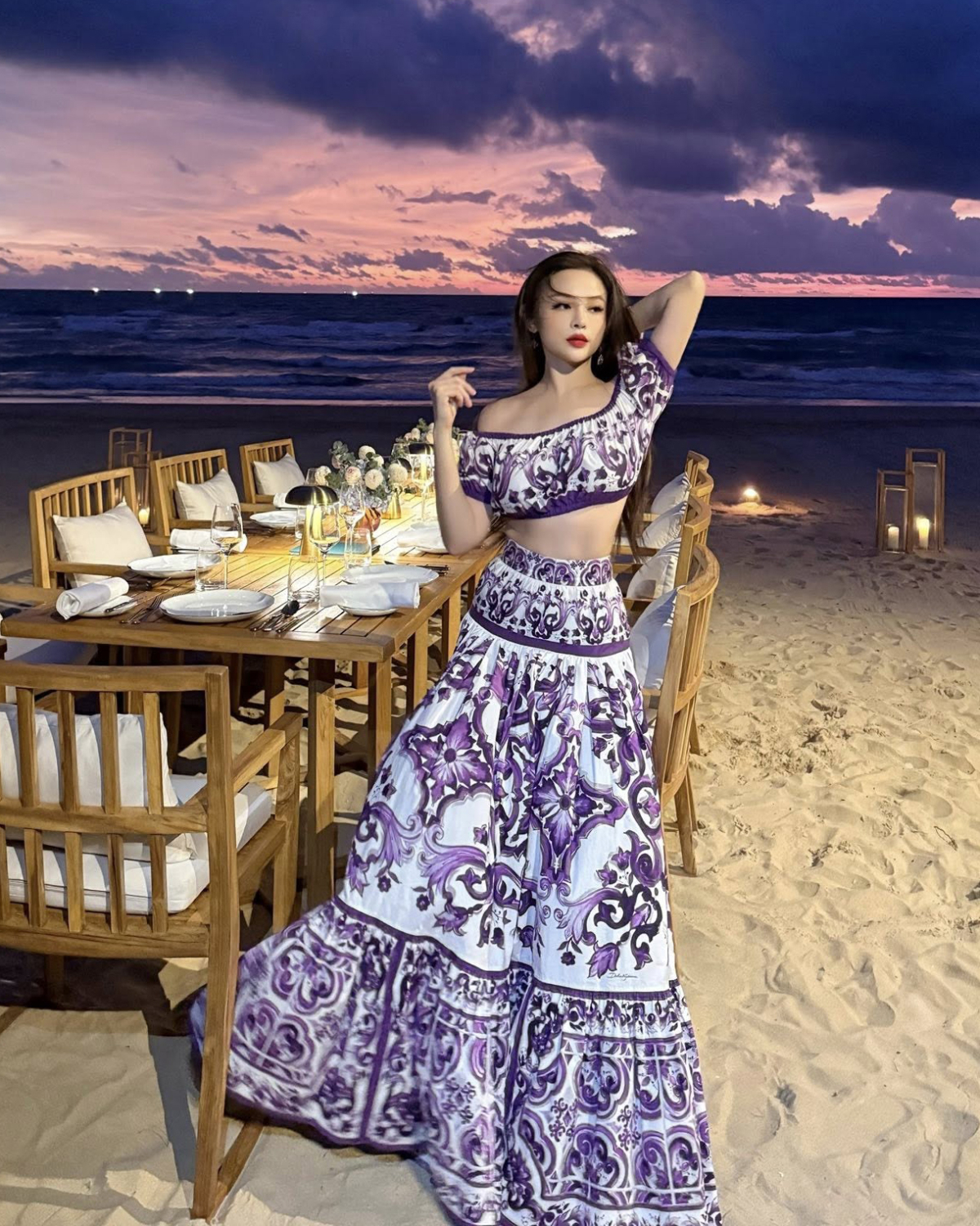 Khoe ảnh trên biển lúc hoàng hôn, Huyền Baby diện set trang phục gồm áo crop top trễ vai và chân váy maxi. Thiết kế mang họa tiết Majolica nằm trong BST mới nhất của Dolce amp; Gabbana, giá bán khoảng hơn 60 triệu đồng cả set.
