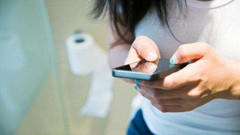 Xem điện thoại khi đi vệ sinh có thể làm tăng áp lực lên tĩnh mạch hậu môn, dễ dẫn đến bệnh trĩ và ảnh hưởng xấu đến mạch máu. (Ảnh minh hoạ).