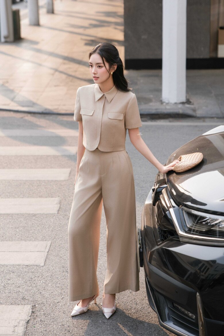 Set đồ monochrome tông beige kết hợp áo lửng và quần suông cạp cao tạo tỷ lệ cơ thể hoàn hảo. Giày cao gót mũi nhọn cùng tông kéo dài chân, mang đến vẻ thanh lịch, hiện đại mà vẫn tôn dáng triệt để.