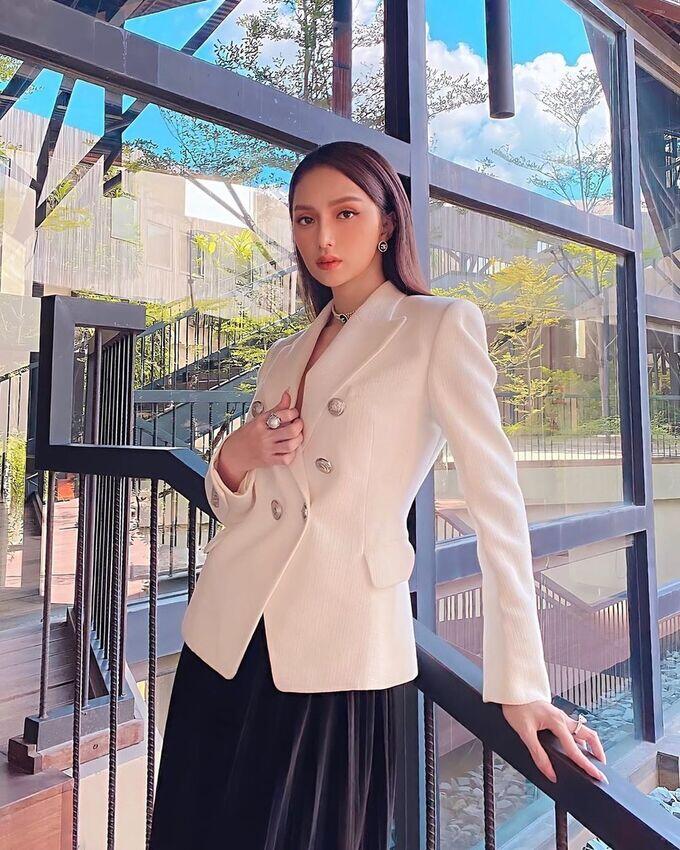 Blazer trắng cài khuy nổi bật trên nền đen quyền lực, tạo điểm nhấn sang trọng và thời thượng, gợi cảm giác quý phái của phong cách menswear hiện đại.