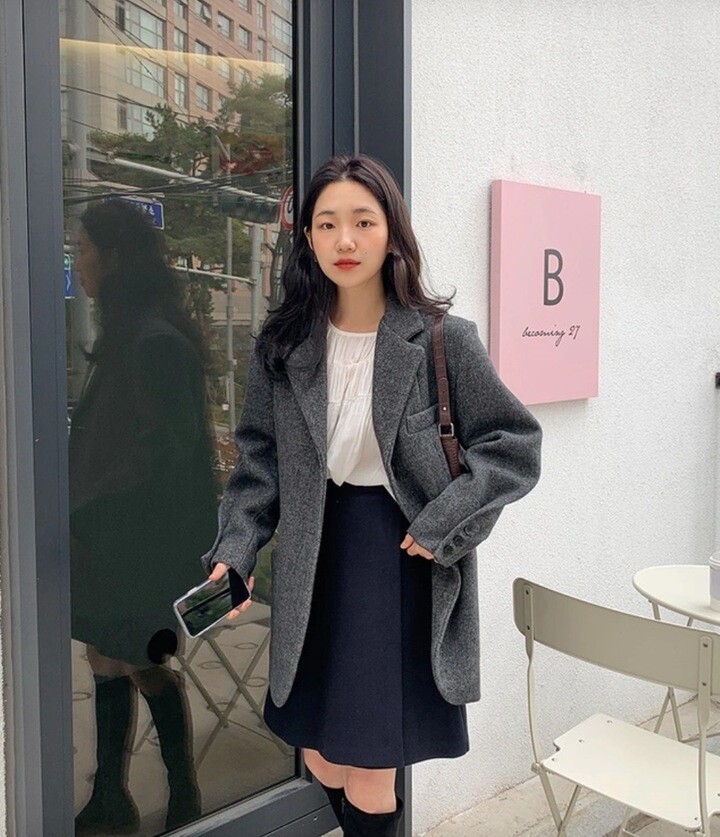 Blazer xám oversize phối áo blouse trắng và chân váy đen, hoàn thiện phong cách preppy trẻ trung nhưng vẫn lịch lãm, thích hợp cho những ngày dạo phố đầu đông.