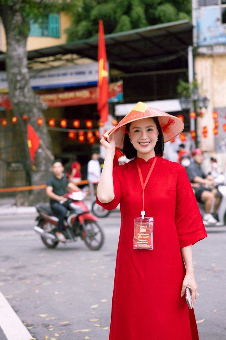 Người đẹp diện áo dài đỏ thắm đơn sắc tôn lên làn da trắng sứ, giúp cô nổi bật trong đám đông.