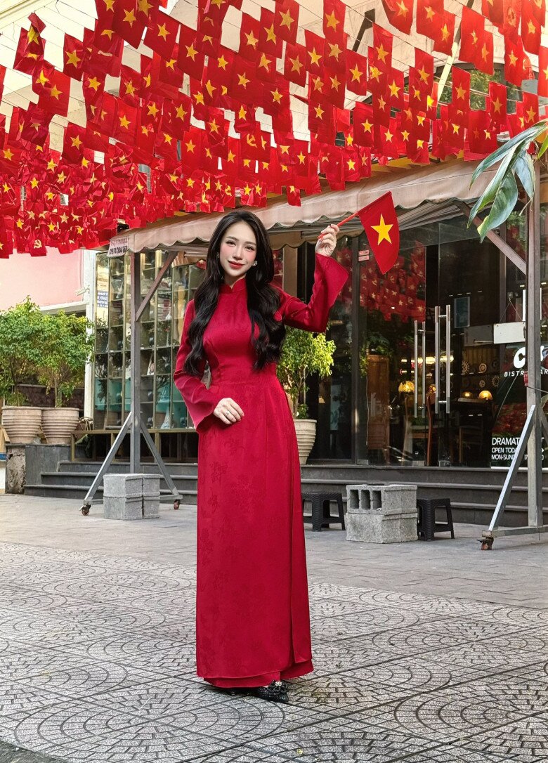 Áo dài thêu họa tiết chìm trông thanh lịch mà vẫn rực rỡ nhờ sắc đỏ nổi bật. Thiết kể cổ cao và ôm theo đường cong giúp cô khoe vóc dáng một cách ý nhị.