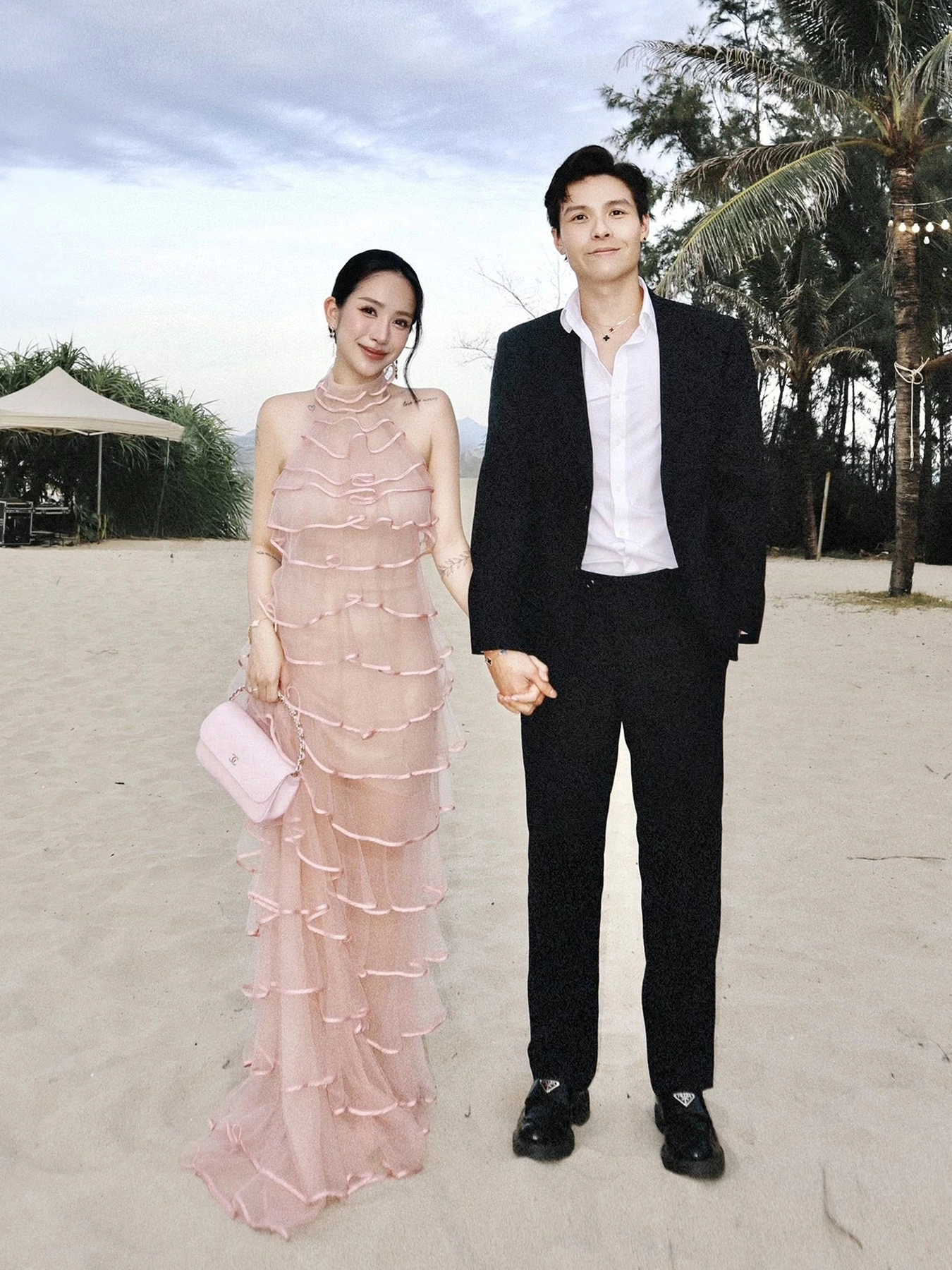 Chưa đầy 2 tháng sau khi chào đón cậu út Jayric, Joyce Phạm xuất hiện yêu kiều trong chiếc váy maxi xếp tầng màu hồng nude kết hợp túi Chanel đồng điệu. Cô đi cùng ông xã Tâm Nguyễn dự sự kiện trên bãi biển hồi giữa tháng 8.