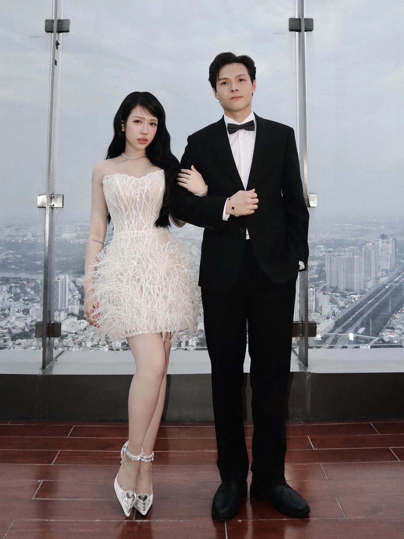 Vài ngày sau, Joyce Phạm dự show thời trang cưới cùng chồng, diện đầm corset ngắn đính lông vũ và giày cao gót mũi nhọn đính đá, tôn trọn đôi chân dài cuốn hút.