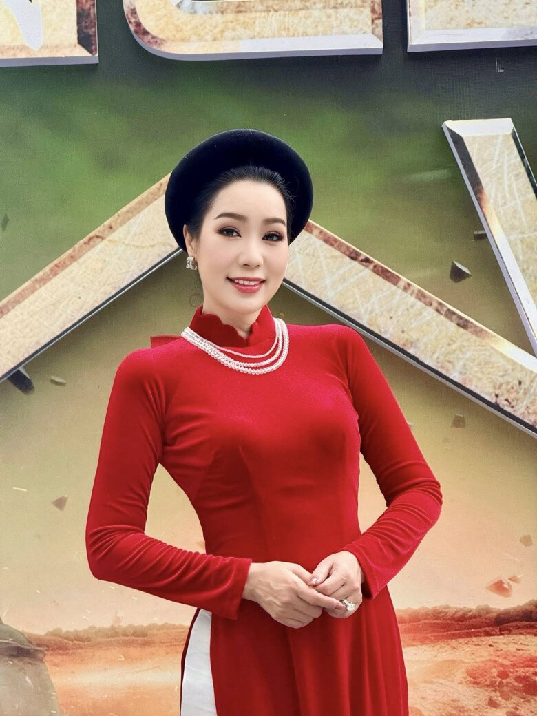 NSND Trịnh Kim Chi kiêu sa trong tà áo dài đỏ nhung sang trọng, tôn trọn vẻ quyền quý và đằm thắm. Chiếc mấn nhung đen cùng chuỗi vòng ngọc trai cổ điển khiến tổng thể trang phục gợi nhớ đến phong thái quý phái của những giai nhân xưa, vừa duyên dáng vừa đầy kiêu hãnh.