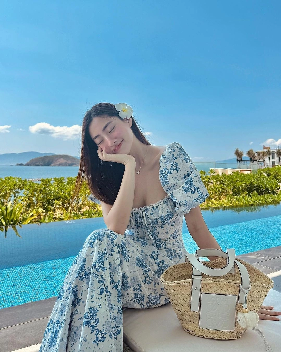 Váy maxi hoa xanh trắng với phần tay phồng và cổ vuông khoe khéo xương quai xanh, che bắp tay đầy tinh tế. Dáng váy chiết nhẹ eo giúp “giấu bụng” khéo léo, mang lại vẻ dịu dàng, tươi tắn cho phụ nữ U40, như trẻ ra cả chục tuổi khi mặc.