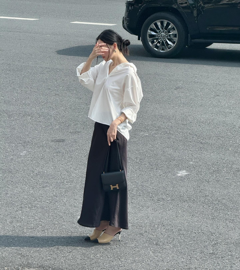 Áo sơ mi trắng ovesize phối cùng chân váy lụa đen mang đến diện mạo thời trang và phóng khoáng.