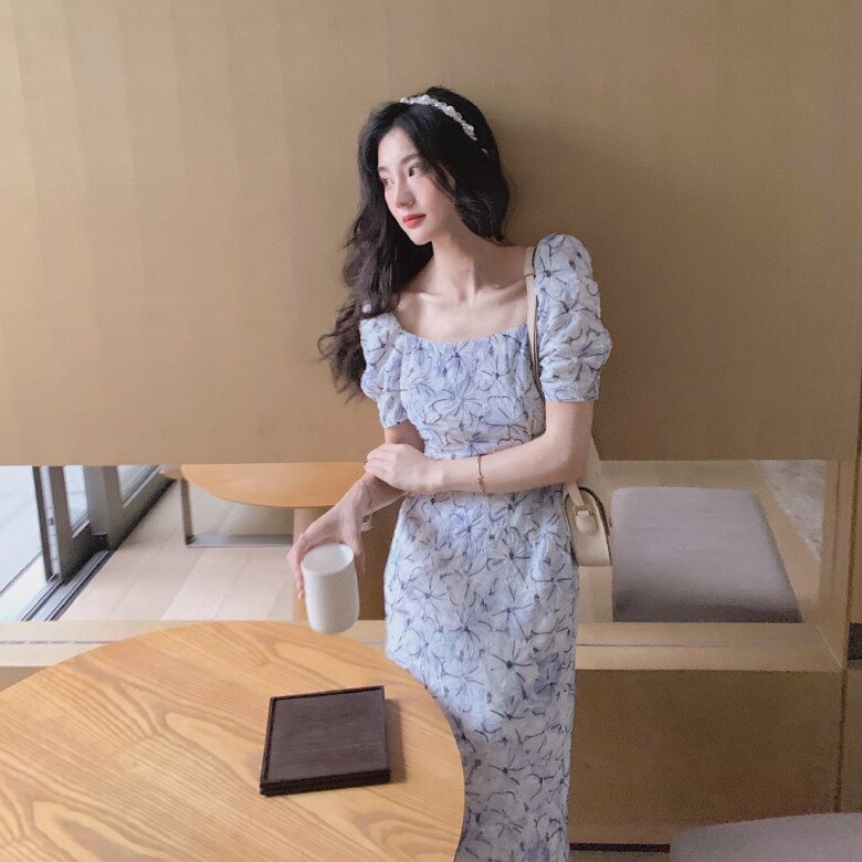 Váy hoa cổ vuông tay bồng mang nét cổ điển, thanh lịch. Thiết kế ôm nhẹ phần eo tôn dáng, tay phồng tạo điểm nhấn nữ tính. Họa tiết hoa nhí tím – xanh mát mẻ, rất hợp để diện đi cà phê hay dạo phố ngày hè.