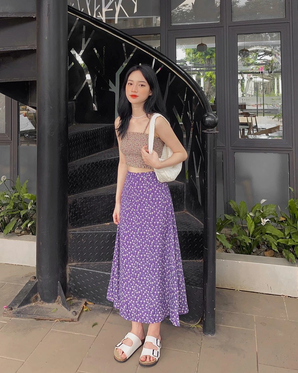 Chân váy hoa tím dáng xoè phối cùng crop top ôm tôn vòng eo gọn gàng. Thiết kế vừa phóng khoáng, vừa nữ tính, thích hợp cho những ngày hè năng động.