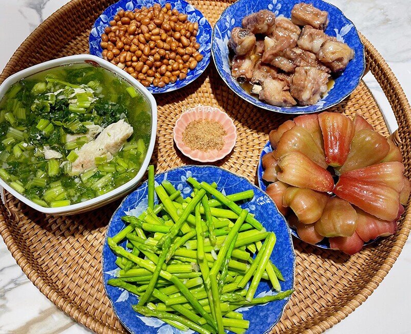 Một mâm cơm đủ sắc đủ vị với sườn rim mềm ngọt, lạc rang muối bùi béo, măng tây xào tỏi giòn tươi. Bát canh cá quả nấu rau cải thanh mát cùng đĩa roi đỏ tráng miệng mọng nước giúp bữa ăn thêm phần cân đối, hài hòa.
(Ảnh: Hòa Bùi)