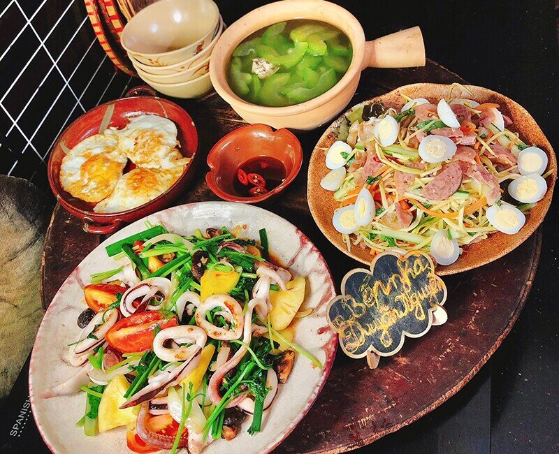 Bữa cơm này đổi món với hải sản: đĩa mực xào chua ngọt hấp dẫn, cùng ché trộn lạ miệng, trứng ốp la giản dị mà ngon cơm. Khép lại là bát canh bí mọc thịt ngọt thanh, khiến mâm cơm thêm phần đủ đầy.
(Ảnh: Thùy Duyên Nguyễn)