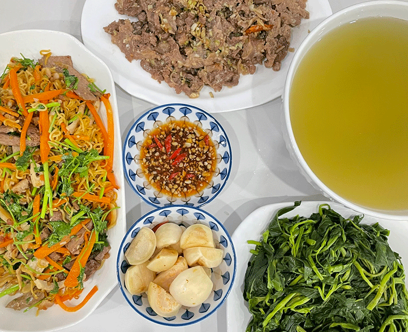 Mì xào bò, cà muối, rau muống luộc, bò xào.  (Ảnh: Phượng Nguyễn)