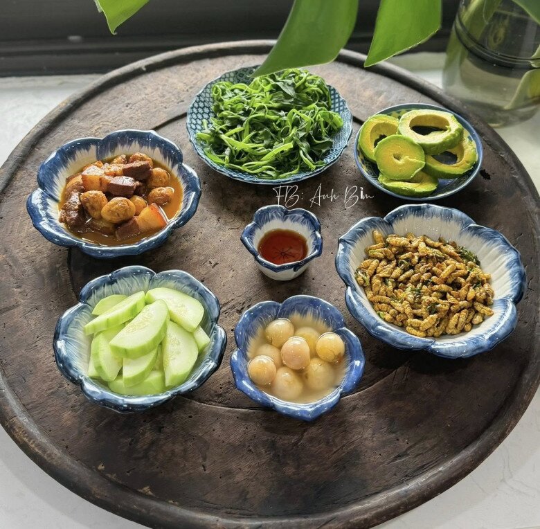 Mâm cơm này có:  Dưa mèo - nhộng rang - cà muối - thịt kho trứng - rau muống luộc - bơ chấm mắm.