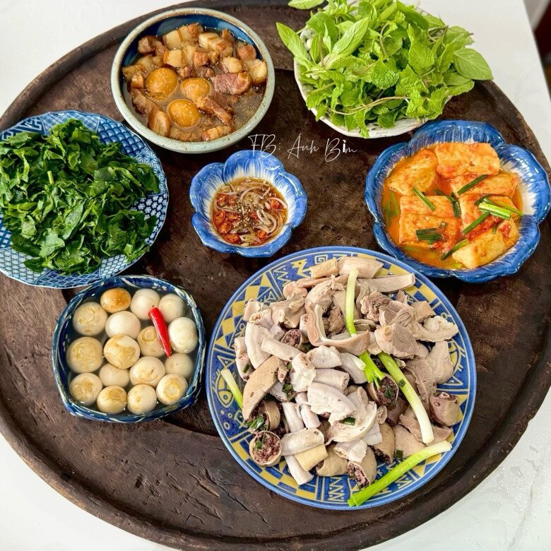Mâm cơm này có: lòng lợn, cà muối, rau ngót luộc, thịt kho trứng, đậu sốt cà chua