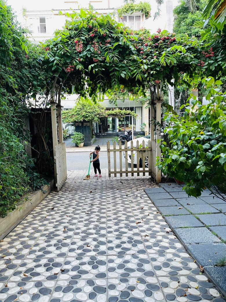 Từ bên trong nhìn ra, lối đi lát đá nổi bật với mái vòm phủ đầy hoa sử quân tử, khung cảnh như một phim trường cổ tích, mẹ con nữ diễn viên được tận hưởng bình yên giữa thiên nhiên ngay trong lòng thành phố.