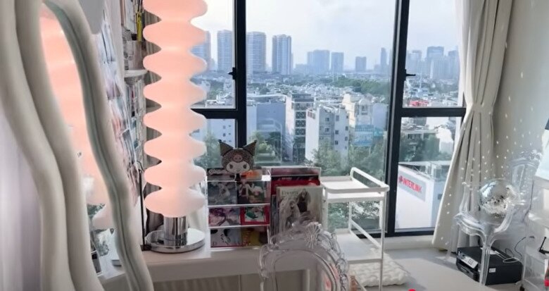 Một góc căn hộ với ánh sáng tự nhiên ngập tràn và tầm nhìn thành phố thoáng đãng. Chiếc đèn bàn kiểu dáng độc đáo cùng các món decor nhỏ xinh làm nổi bật gu thẩm mỹ riêng biệt của chủ nhân.